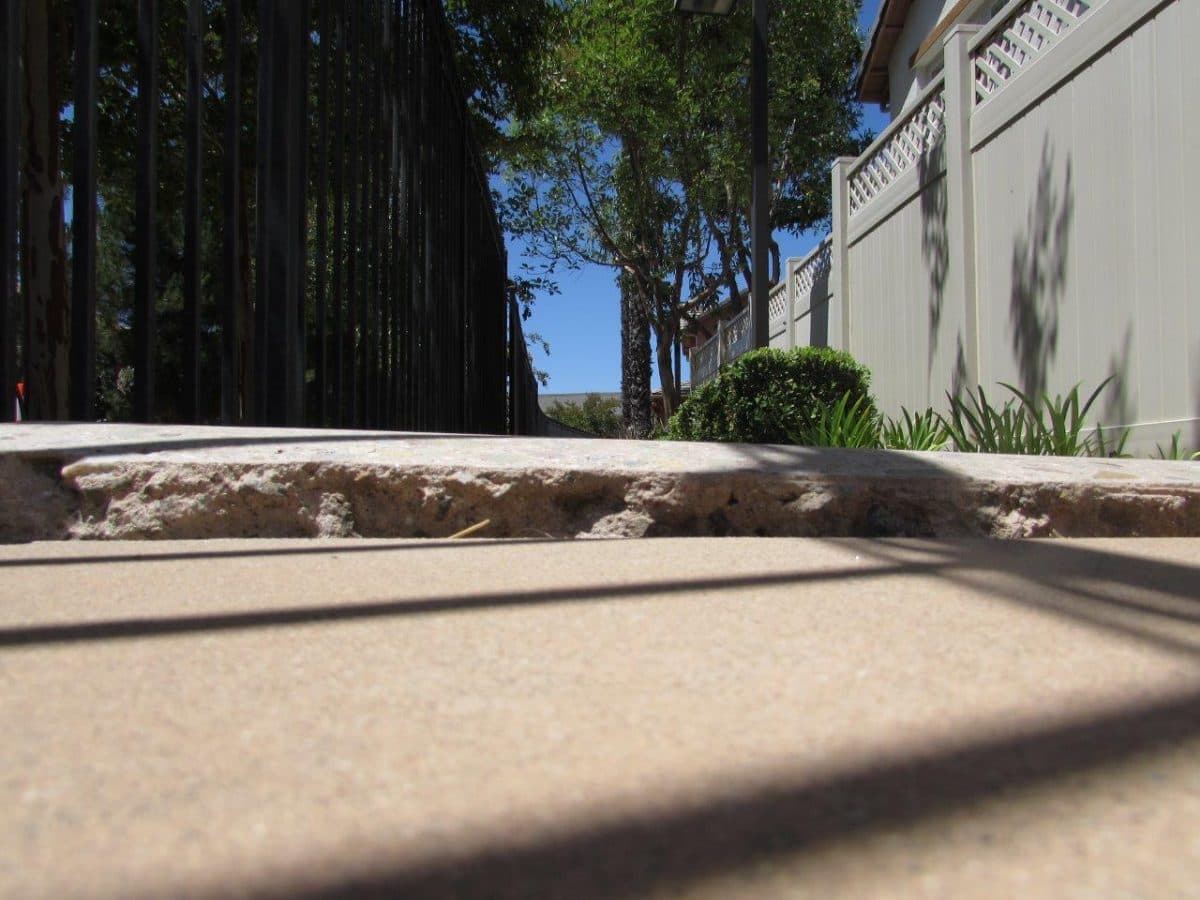 Raised concrete walkway lip before trip hazard repair